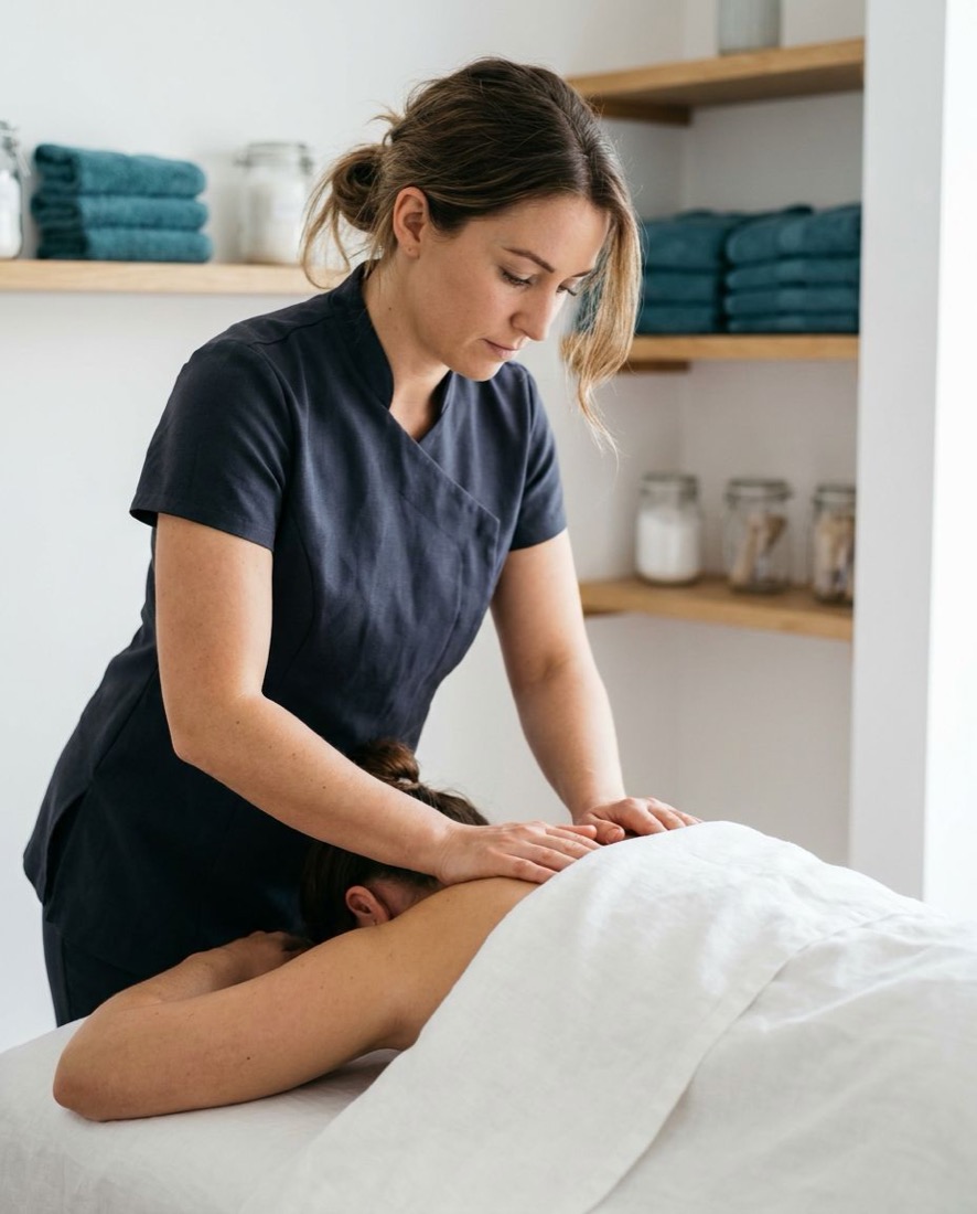 A massage therapist working on a client’s shoulders